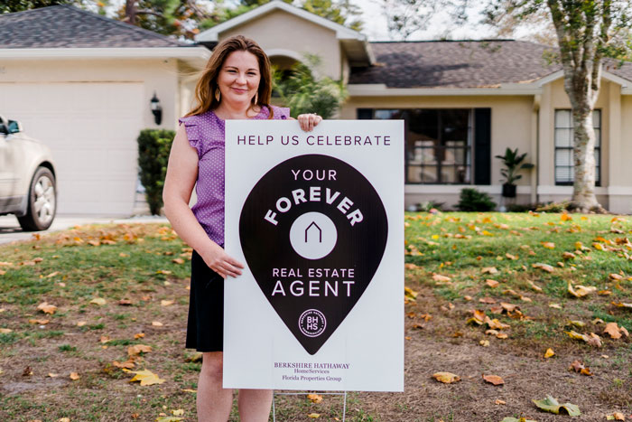 Spring Hill Real Estate Agent Jocelyn mejia standing next to a yard sign